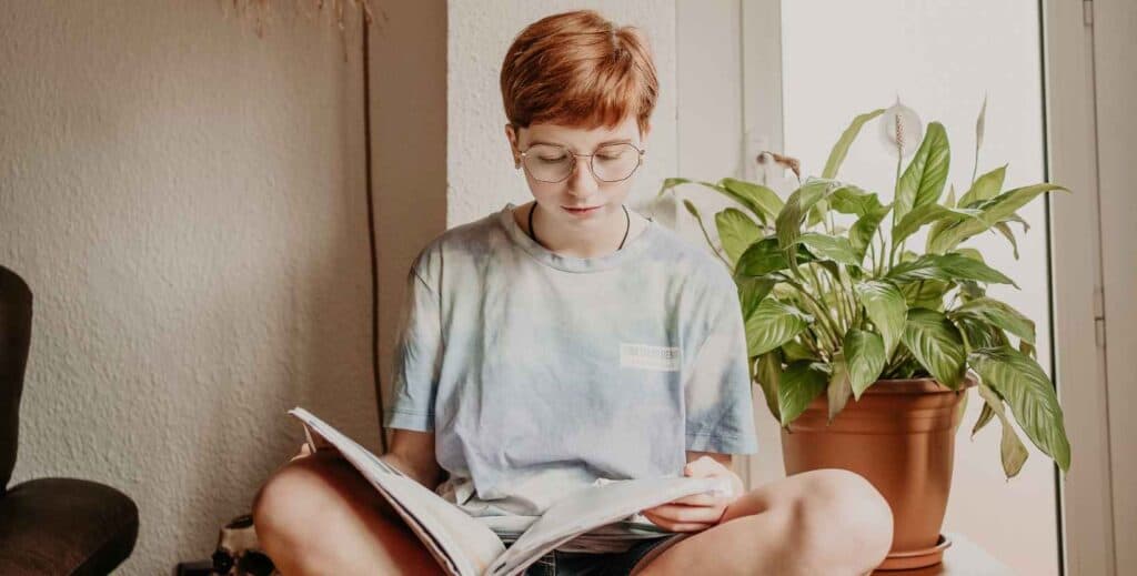 Imagen de una chica adolescente leyendo un libro.